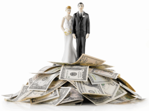 bride and groom cake toppers on a pile of cash